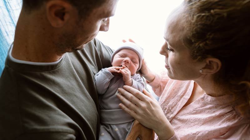 Parents holding newborn together