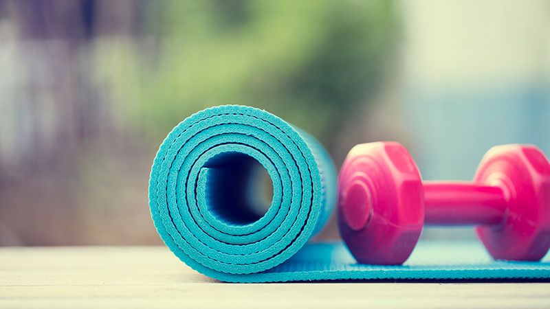 una colchoneta de yoga y una pesa de mano