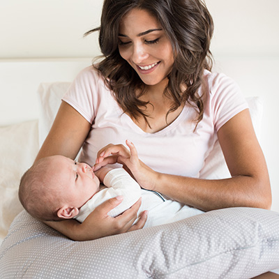 young mother holds baby in bed young mother holds baby in bed